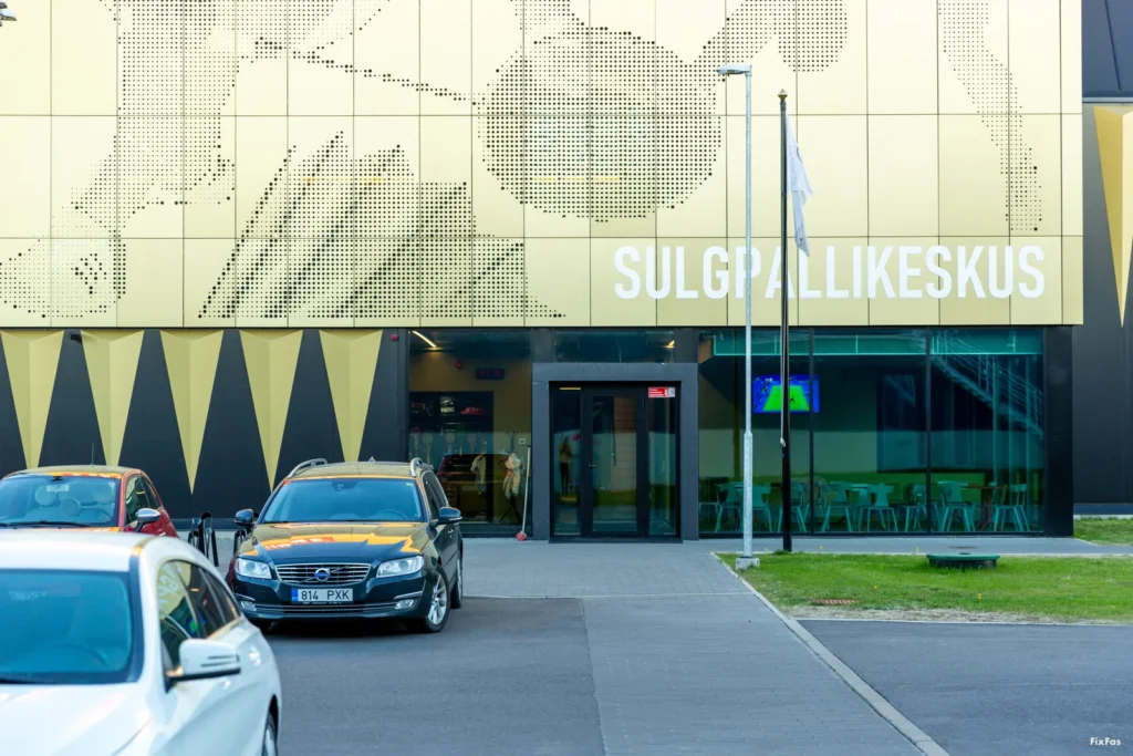 Lenne Sulgpallikeskuse sissepääs, kus Golden metallic fassaadipaneelidel kujutatakse sulgpalli liikumise dünaamikat, luues unikaalse visuaalse efekti.